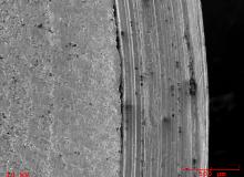 SEM view of fracture surface. Note what appears to be a deep machining mark along the edge. _0